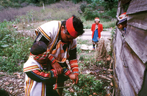 布農族舉行重要的祭典射耳祭，一名男子正在教導小孩子學習射擊。（李道明提供）