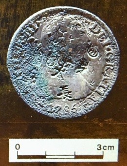 圖11：西班牙卡洛斯三世8Real銀幣（銀幣正面為國王半身胸像，面容與衣褶線條較為模糊，邊緣一處銅鏽包覆，但仍可辨識銘文：「DEI ?GRATIA1785【CAROLUS】 III」，意為蒙神恩寵，1785年，卡洛斯三世（CAROLUS III）。銀幣正面可見多處戳印符號，如「帶圈王字」、「長」、「天」等。）（資料來源：盧泰康，2015：182圖17）